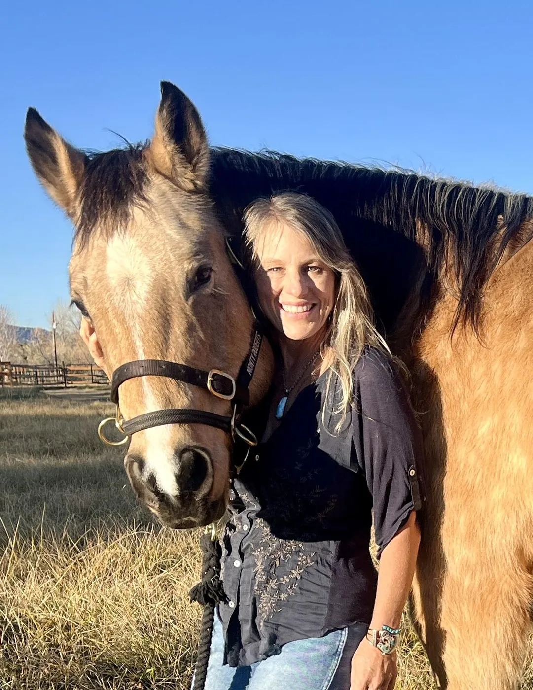 Julie Meyers of Serenity Horse hugging a buckskin horse